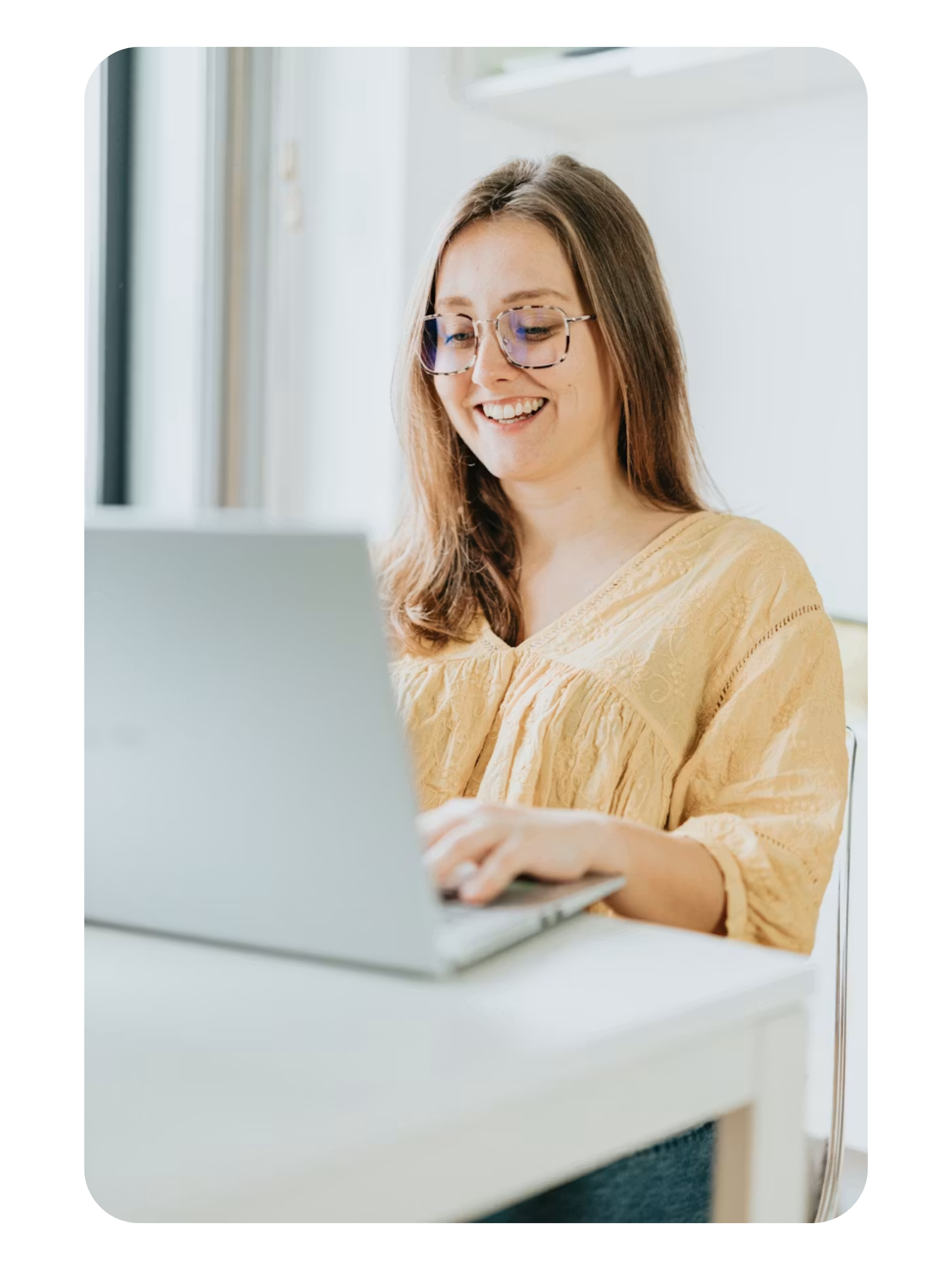 A professional working on a laptop in a bright home office