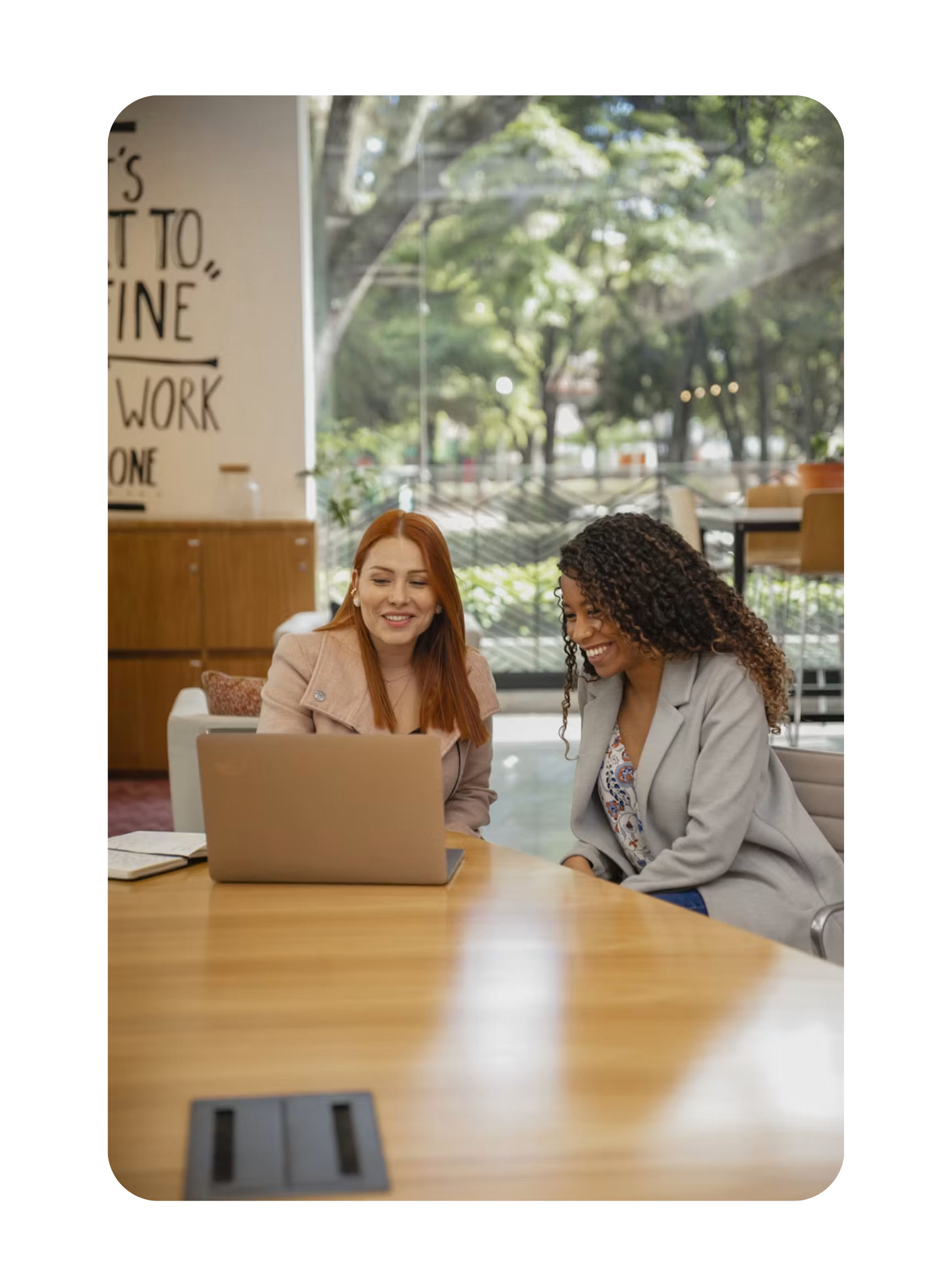 Two colleagues reviewing AI workforce data together at a laptop